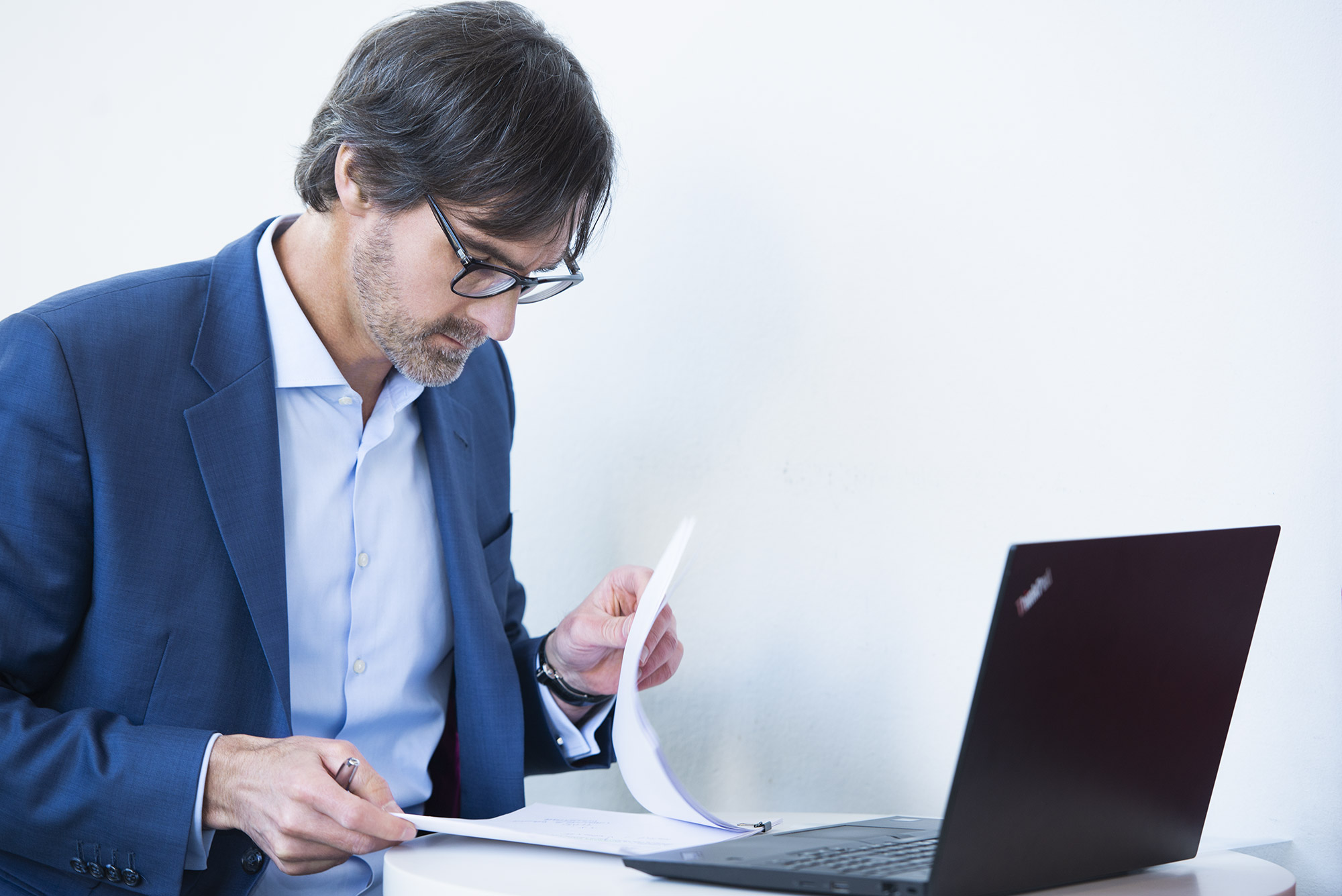 Matthias Struck liest in Unterlagen und ein Notebook ist aufgeklappt